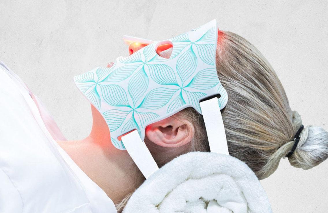 Woman lying with the LED device on her face Woman lying with the LED device on her face