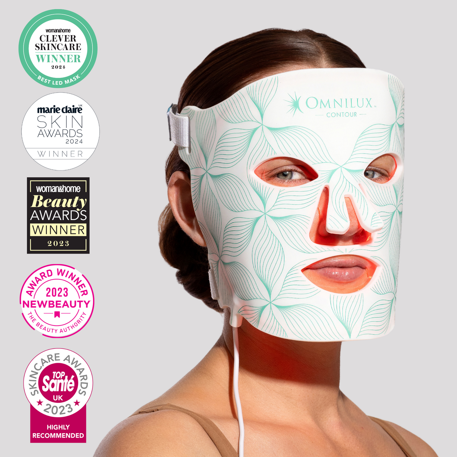 Woman wearing an Omnilux LED face mask with multiple award badges on a light gray background