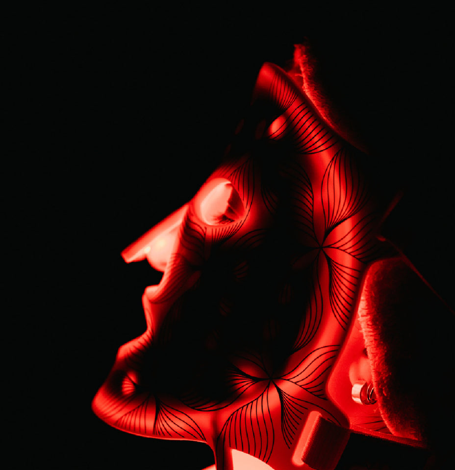 Woman using Omnilux LED mask in a dark room